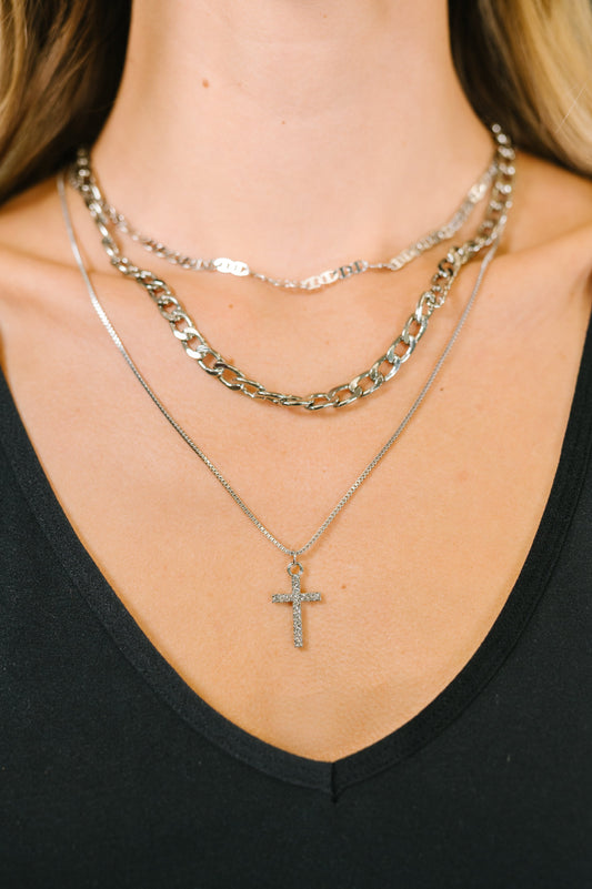 Layered silver faith necklace with pavé cross pendant and mixed chain styles