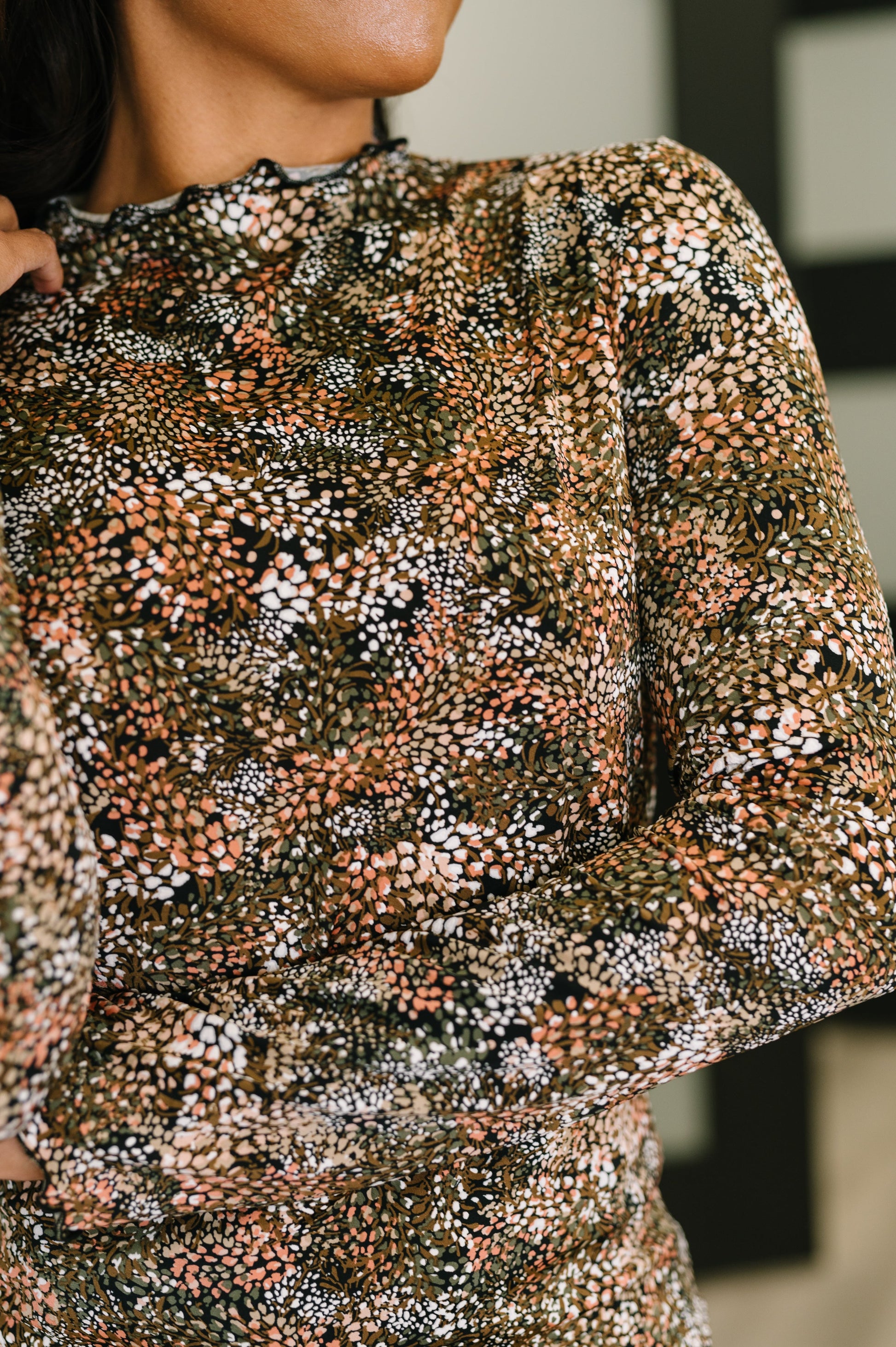  Women wearing black, green, tan, white multi color design long sleeve textured knit top with lettuce hem neckline, cuffs, and hem, flattering high-stretch fit